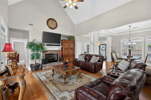 a kitchen with stainless steel appliances granite countertop a refrigerator a oven a sink a stove and a dining table with wooden floor