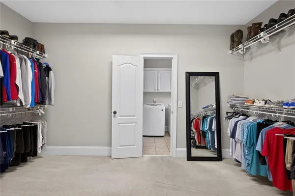 a walk in closet with white walls