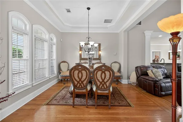 a view of a dining room with furniture a chandelier and wooden floor