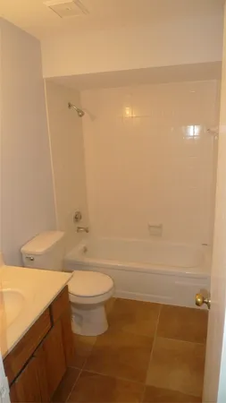 a white toilet sitting next to a bathtub