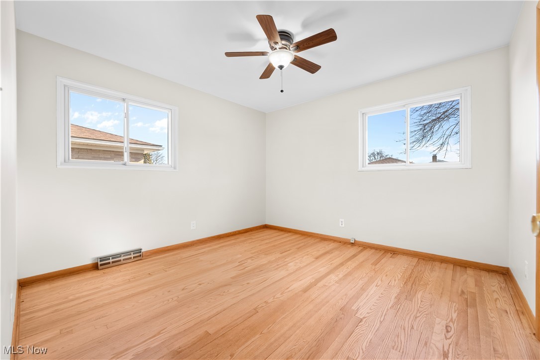 615 Ingalls Road Akron, OH 44312 - Photo 33 of 50 Spare room with light wood-type flooring, baseboards, visible vents, and a ceiling fan