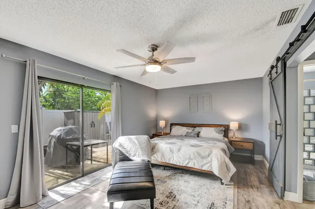 a bedroom with a bed and a large window with balcony view