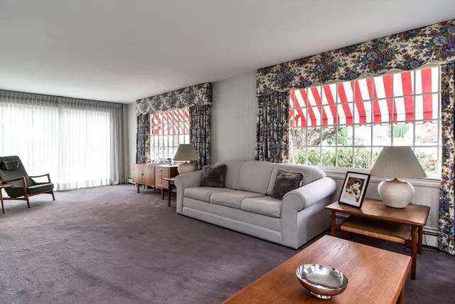 a living room with furniture fireplace and a large window