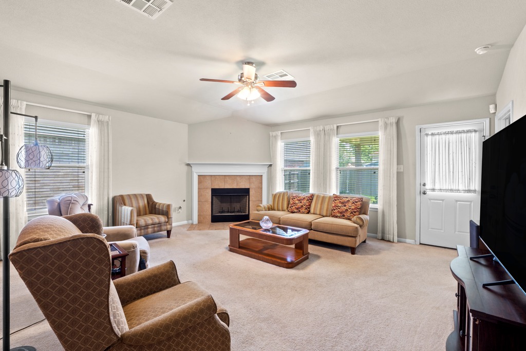 12008 Lansdowne Road Austin, TX 78754 - Photo 6 of 29 A welcoming living area featuring a fireplace and abundant natural light through multiple windows.