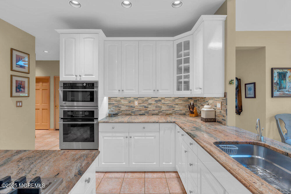 203 Stone Hill Road Freehold, NJ 07728 - Photo 16 of 83 a kitchen with granite countertop a sink stainless steel appliances and white cabinets