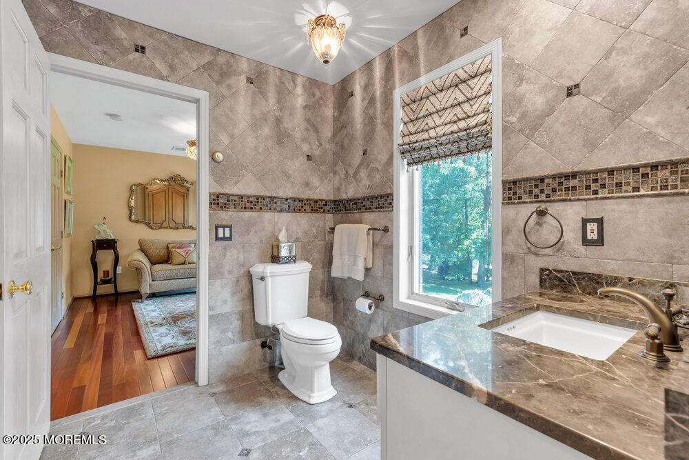 203 Stone Hill Road Freehold, NJ 07728 - Photo 39 of 83 a bathroom with a granite countertop sink a toilet a mirror and shower