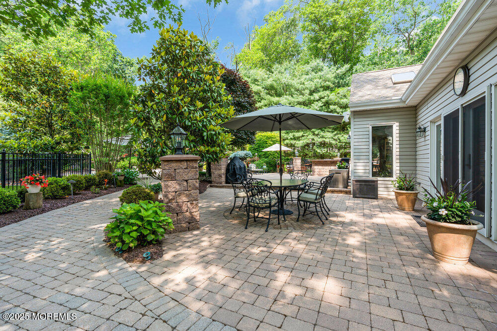 203 Stone Hill Road Freehold, NJ 07728 - Photo 77 of 83 a view of a patio with table and chairs under an umbrella