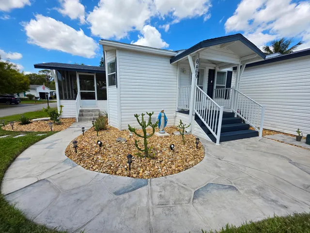 a view of a house with backyard and sitting area