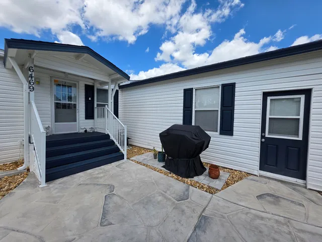 a view of a deck with table and chairs with wooden floor and fence and a barbeque
