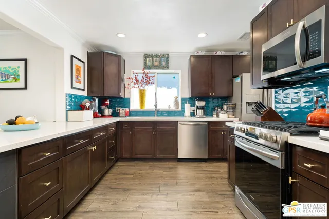 a kitchen with stainless steel appliances granite countertop a sink a stove top oven a counter space and cabinets