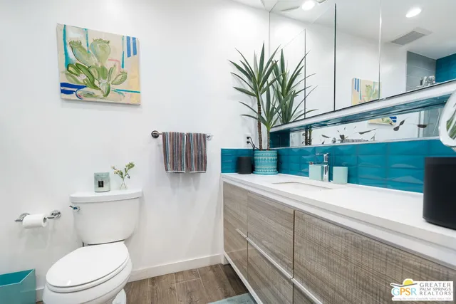 a bathroom with a sink a toilet and a mirror