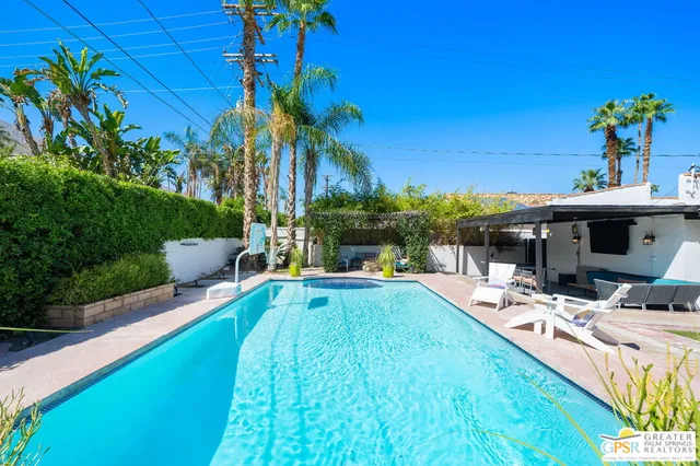 a view of a house with swimming pool and sitting area
