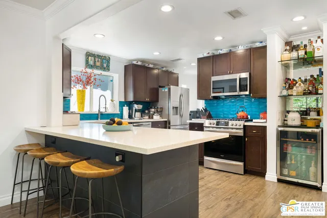 a kitchen with stainless steel appliances a stove a sink a refrigerator and a refrigerator