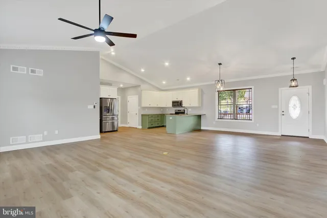 a view of kitchen with granite countertop stainless steel appliances and a wooden floor