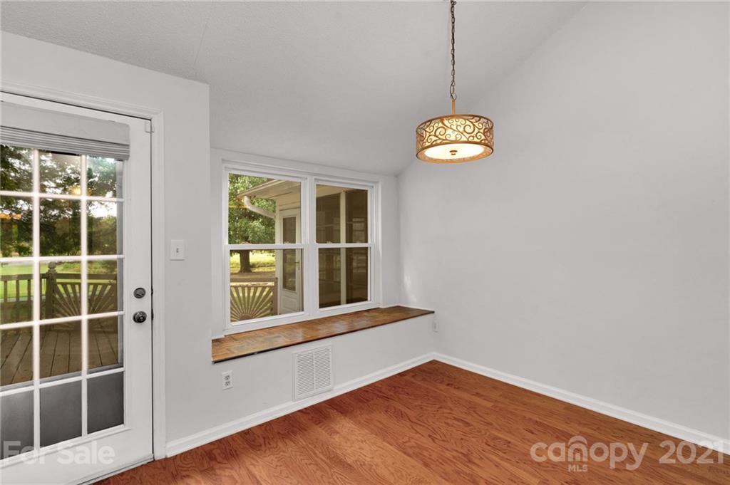 9838 Fairway Ridge Road, Unit 11 Charlotte, NC 28277 - Photo 15 of 40 a view of an empty room with a window and wooden floor