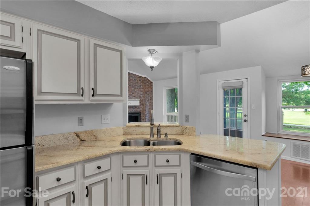 9838 Fairway Ridge Road, Unit 11 Charlotte, NC 28277 - Photo 19 of 40 a kitchen with stainless steel appliances granite countertop a sink and white cabinets