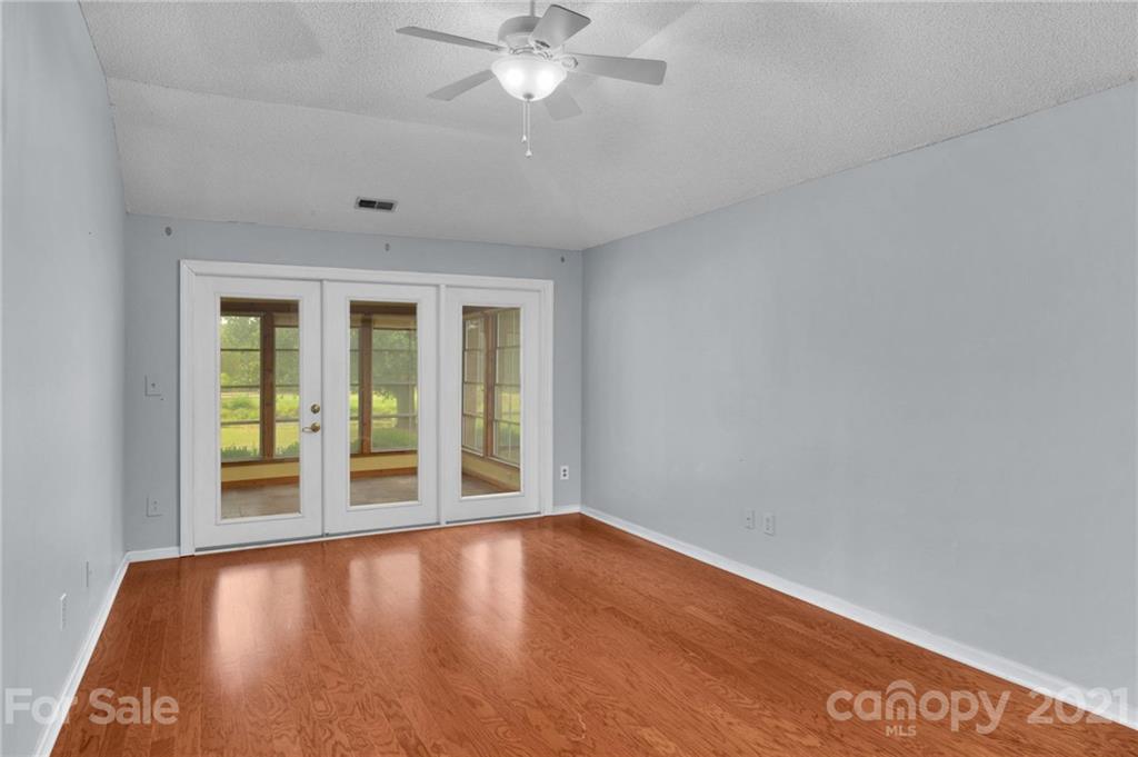 9838 Fairway Ridge Road, Unit 11 Charlotte, NC 28277 - Photo 21 of 40 an empty room with wooden floor fan and windows