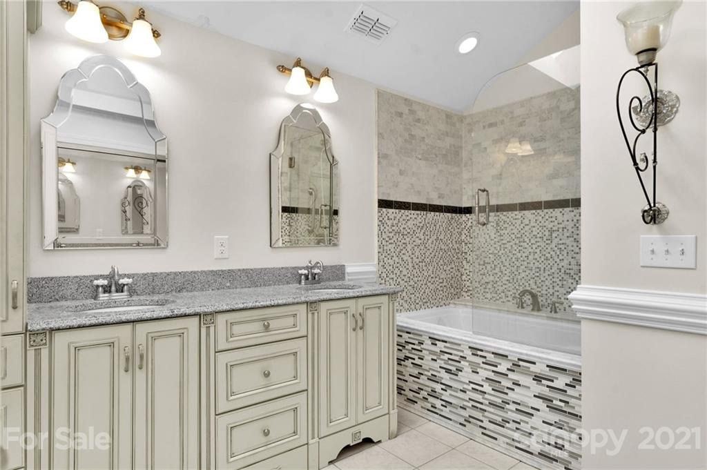 9838 Fairway Ridge Road, Unit 11 Charlotte, NC 28277 - Photo 24 of 40 a bathroom with a granite countertop sink a toilet a mirror a vanity and bathtub