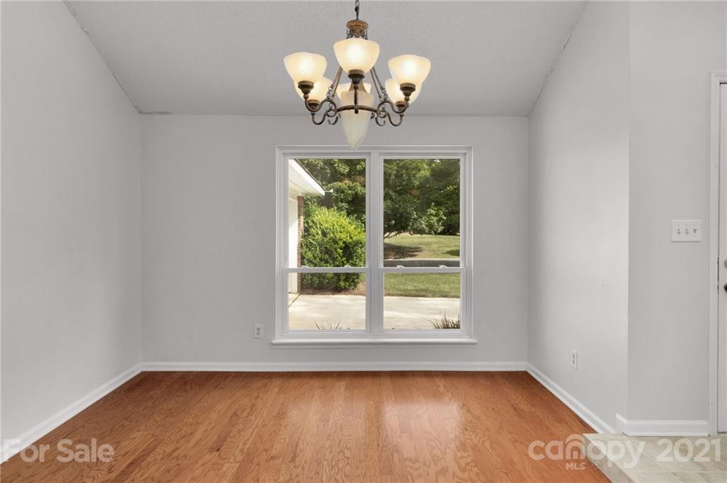 9838 Fairway Ridge Road, Unit 11 Charlotte, NC 28277 - Photo 9 of 40 a view of a room with wooden floor and chandelier