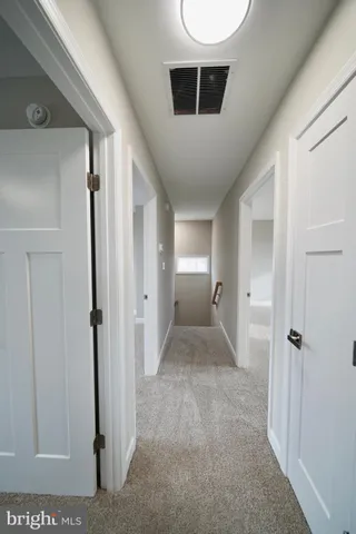 an empty room with windows and ceiling fan
