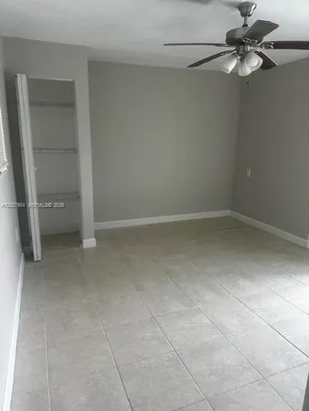 a view of an empty room and a chandelier fan