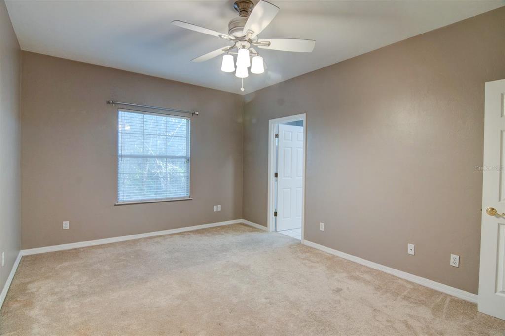 4933 Northwest 1st Place, Unit 110 Gainesville, FL 32607 - Photo 12 of 31 an empty room with windows and chandelier fan