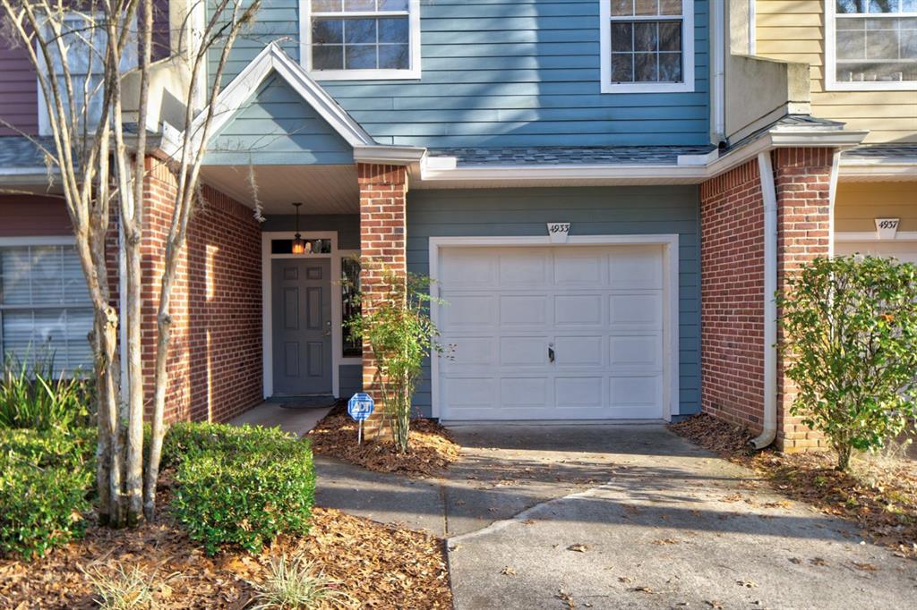 4933 Northwest 1st Place, Unit 110 Gainesville, FL 32607 - Photo 2 of 31 a front view of a house with a yard and garage