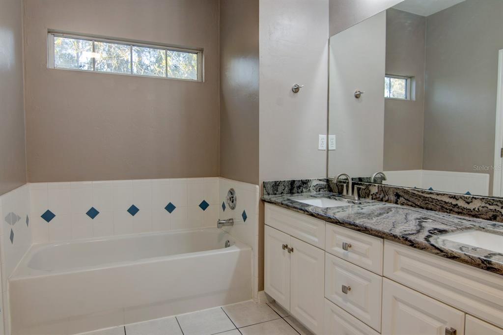 4933 Northwest 1st Place, Unit 110 Gainesville, FL 32607 - Photo 22 of 31 a bathroom with a tub sink and mirror
