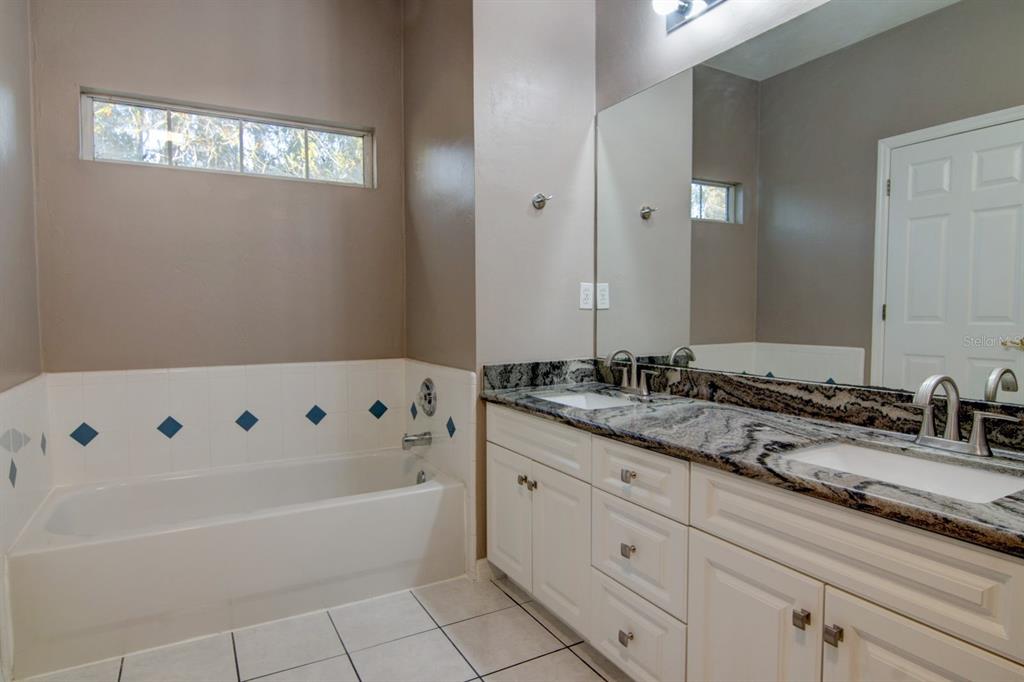 4933 Northwest 1st Place, Unit 110 Gainesville, FL 32607 - Photo 23 of 31 a bathroom with a tub a sink and mirror