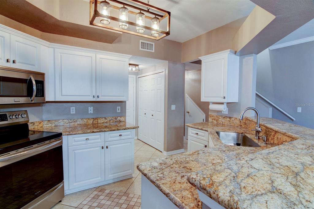 4933 Northwest 1st Place, Unit 110 Gainesville, FL 32607 - Photo 5 of 31 a kitchen with stainless steel appliances granite countertop a sink stove and refrigerator