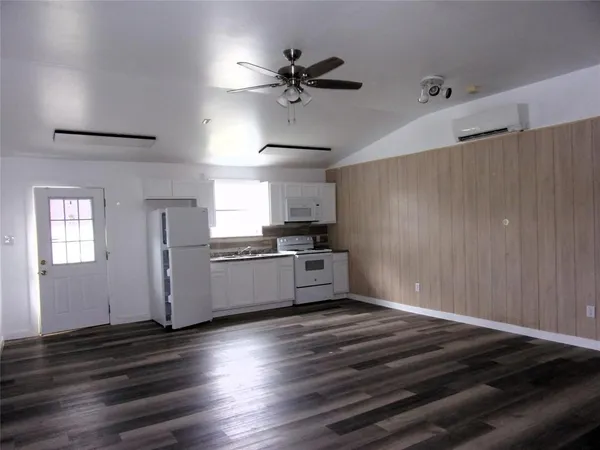 a kitchen with granite countertop a stove cabinets and wooden floor