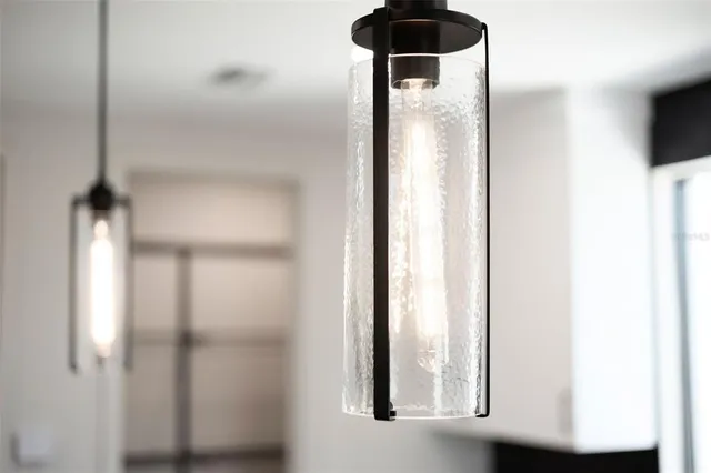 a open kitchen with stainless steel appliances granite countertop a stove top oven a sink dishwasher a dining table and chairs with wooden floor