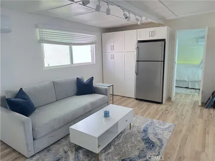 a living room with furniture and a refrigerator
