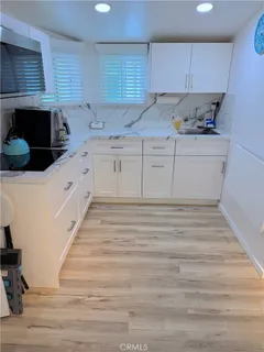 a kitchen with granite countertop a sink and cabinets