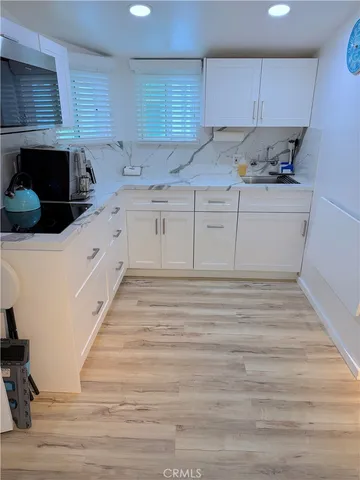 a kitchen with granite countertop a sink and cabinets