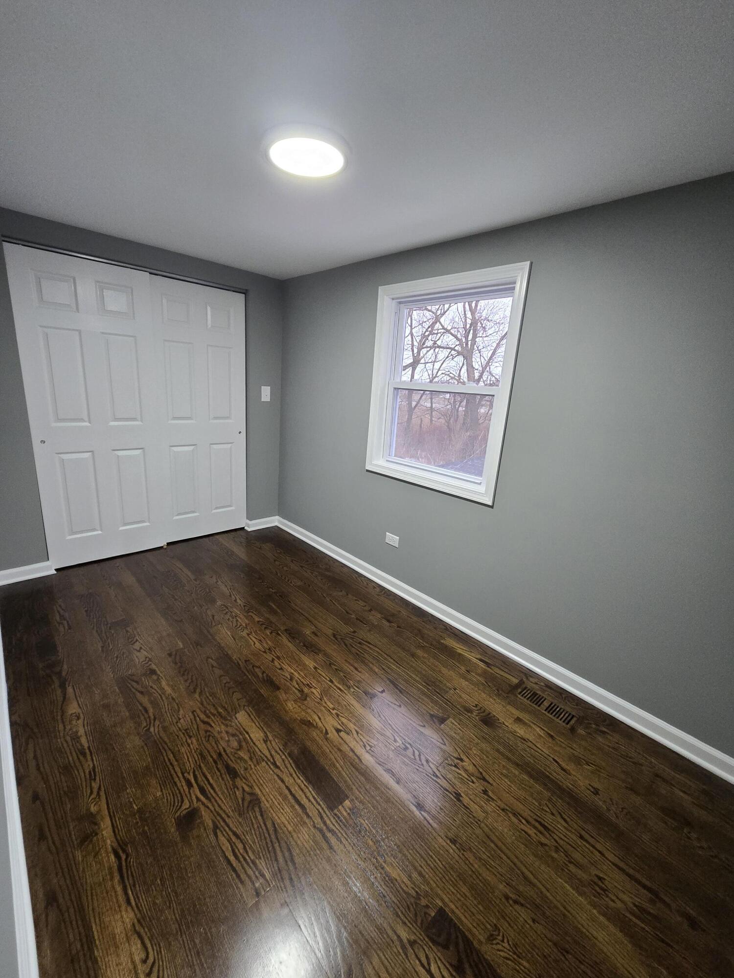 2100 West 2nd Avenue Gary, IN 46404 - Photo 12 of 22 an empty room with wooden floor and windows