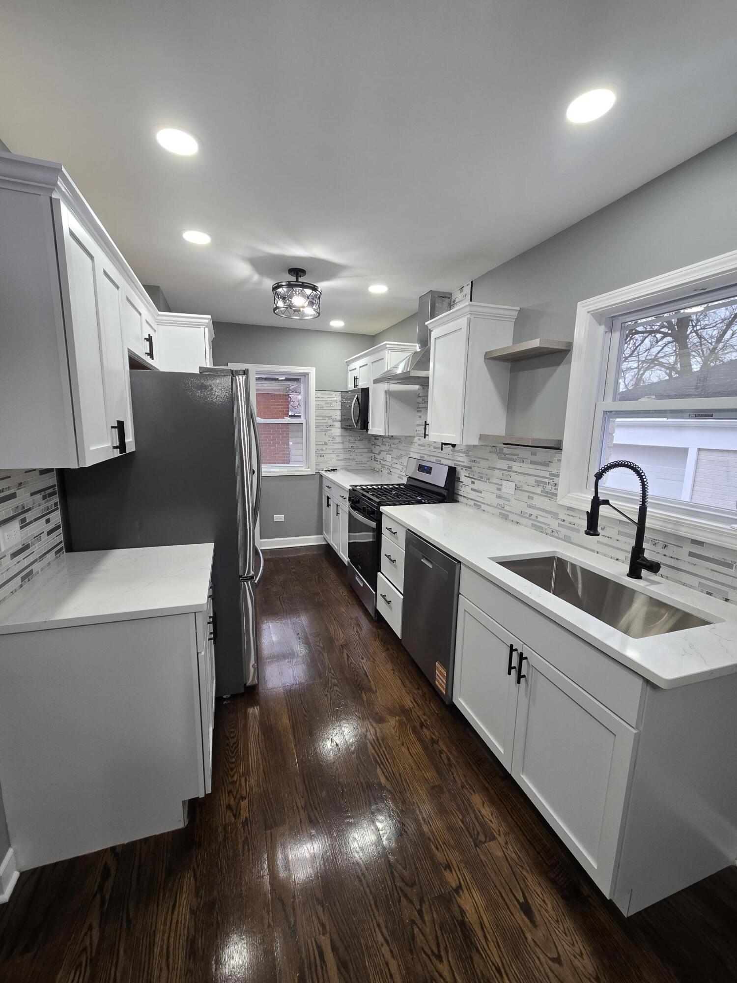 2100 West 2nd Avenue Gary, IN 46404 - Photo 5 of 22 a large kitchen with stainless steel appliances sink a microwave and cabinets