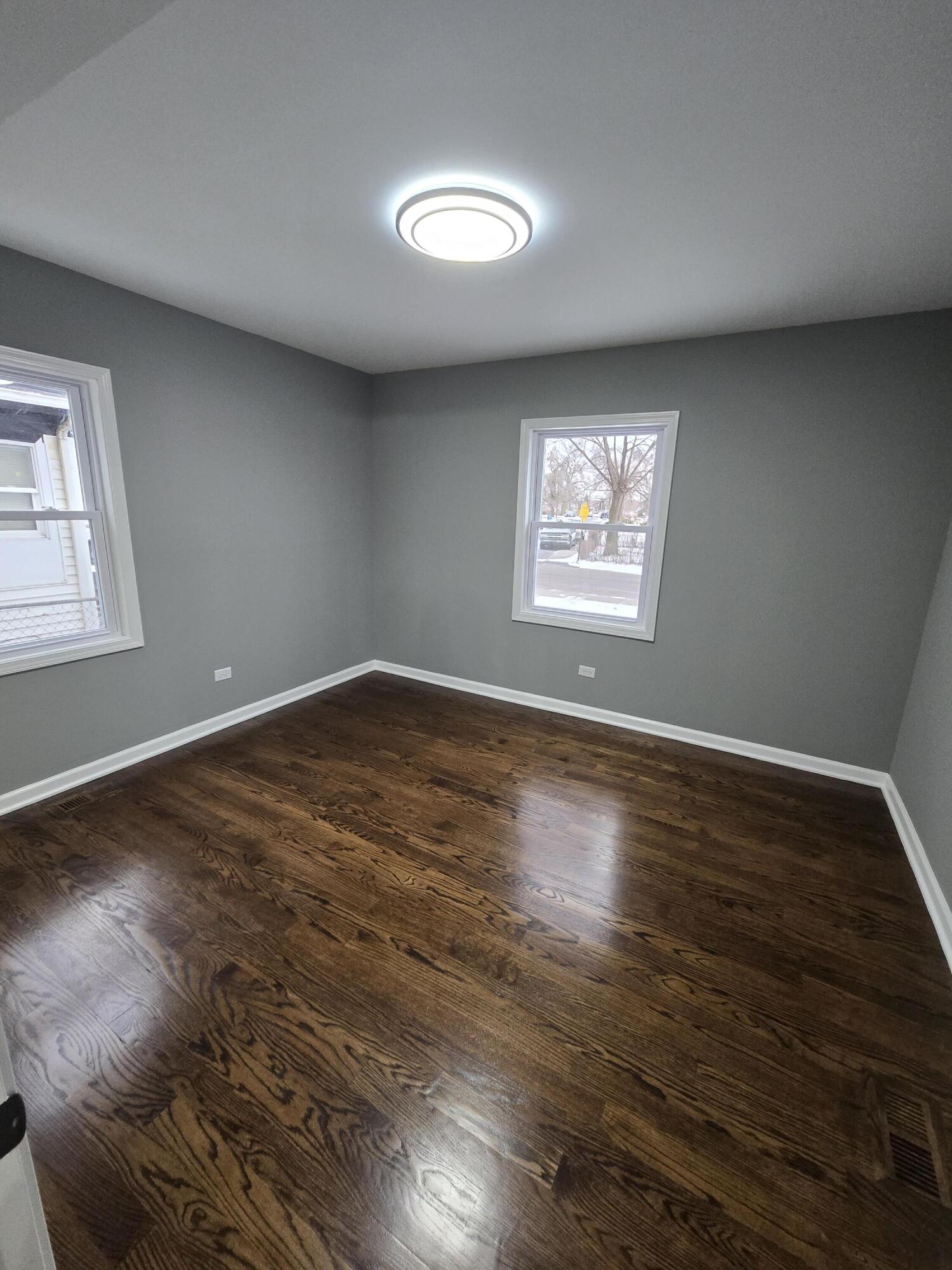 2100 West 2nd Avenue Gary, IN 46404 - Photo 9 of 22 an empty room with wooden floor and windows