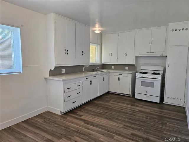 a kitchen with granite countertop white cabinets and white appliances