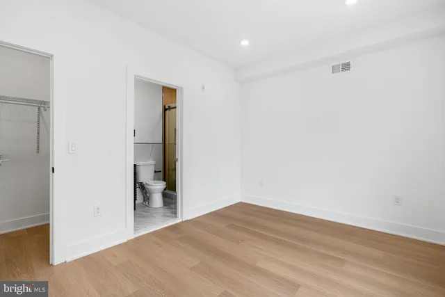 a view of a room with wooden floor and a ceiling fan