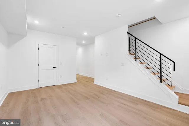 a view of room with stairs and wooden floor