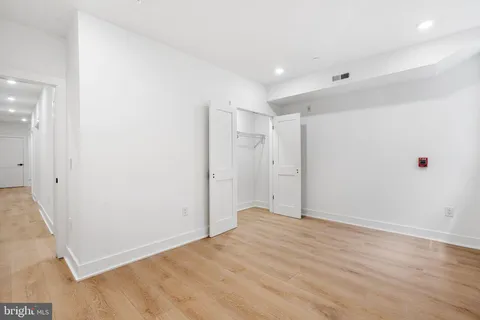 a kitchen with stainless steel appliances granite countertop a sink a stove a wooden floor and a large window