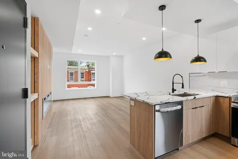 a view of kitchen with stainless steel appliances kitchen island wooden floor and window