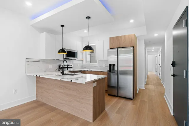 a kitchen with stainless steel appliances granite countertop a sink refrigerator and microwave