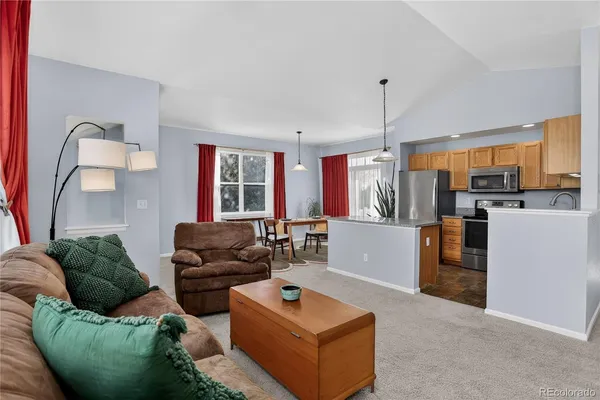 a living room with furniture and a open kitchen view