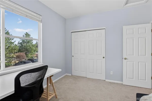 a view of a room with a large window and wooden floor