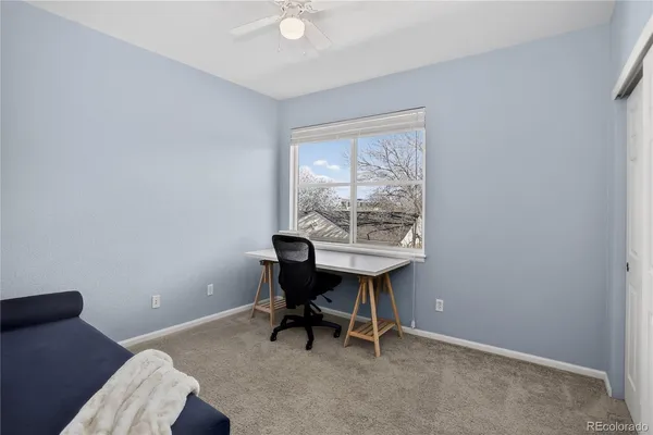 a view of a workspace with furniture and a window