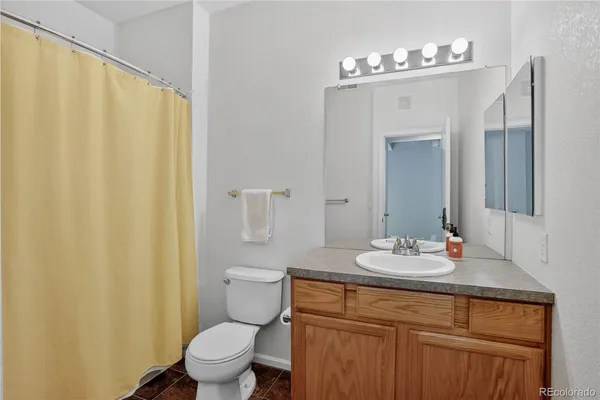 a bathroom with a sink a toilet and shower curtain