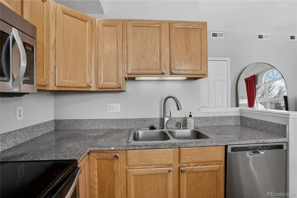 a kitchen with stainless steel appliances granite countertop a sink a stove microwave and cabinets
