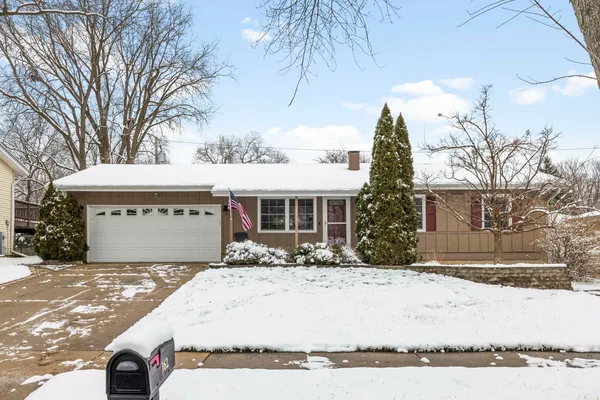 a front view of house with yard covered in snow